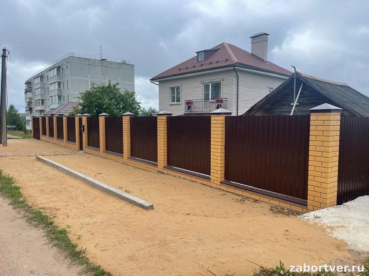 Комбинированный забор из коричневого профнастила и желтого кирпича на ленточном фундаменте