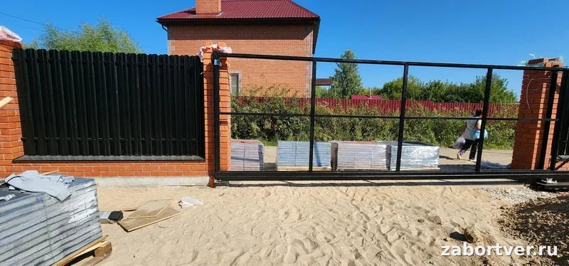 Установка каркаса черных откатных ворот и забора из профнастила на красных кирпичных столбах, строительство ограждения под ключ