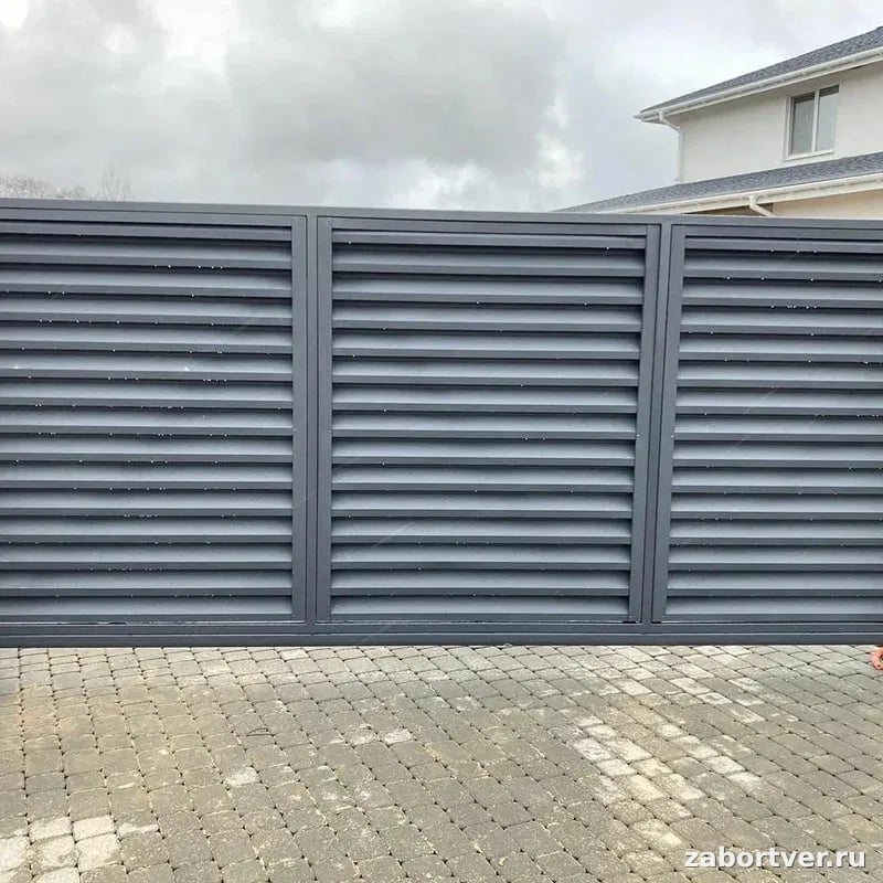 Современные серые откатные ворота жалюзи из металлических ламелей на фоне частного дома