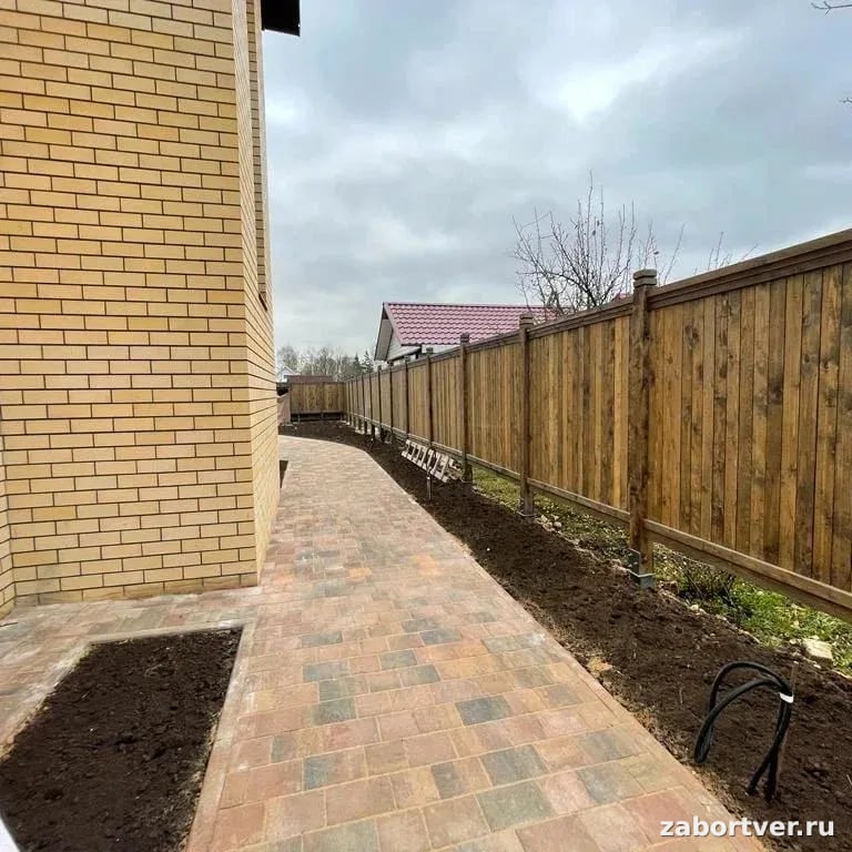 Сплошной деревянный забор темно-коричневого цвета