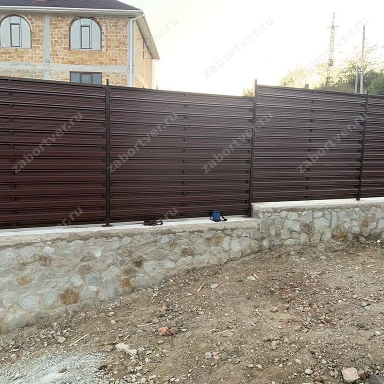 Тёмный забор-жалюзи на каменном цоколе