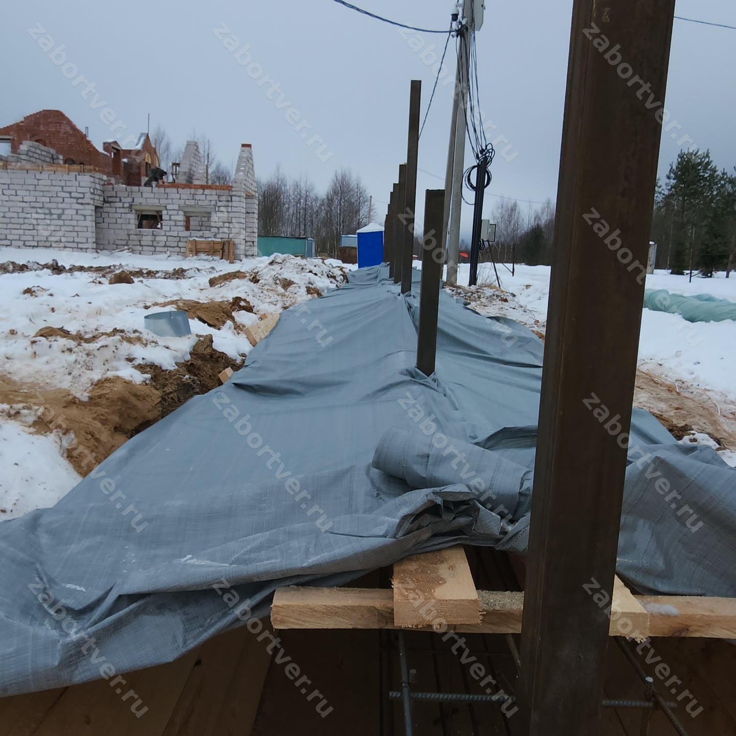 Этап монтажа забора в зимний период: установлены металлическ